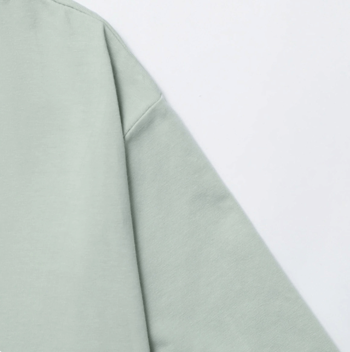 Close-up view of a sage green sports loose crop top sleeve, showcasing smooth fabric ideal for yoga or training.