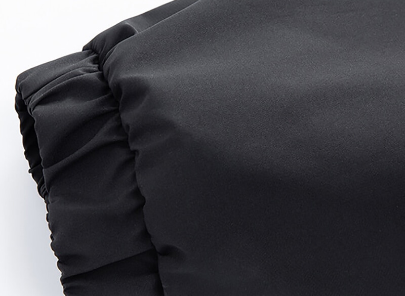 Close-up of black sports men's hooded thin jacket with reflective strips, showing ruched fabric detail.
