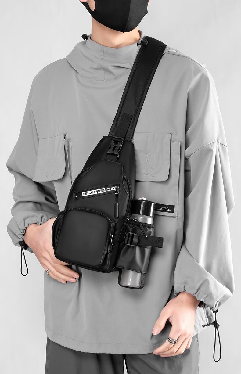 Man wearing sports multifunctional crossbody bag with USB-port and water bottle holder, stylish and functional design for daily use.