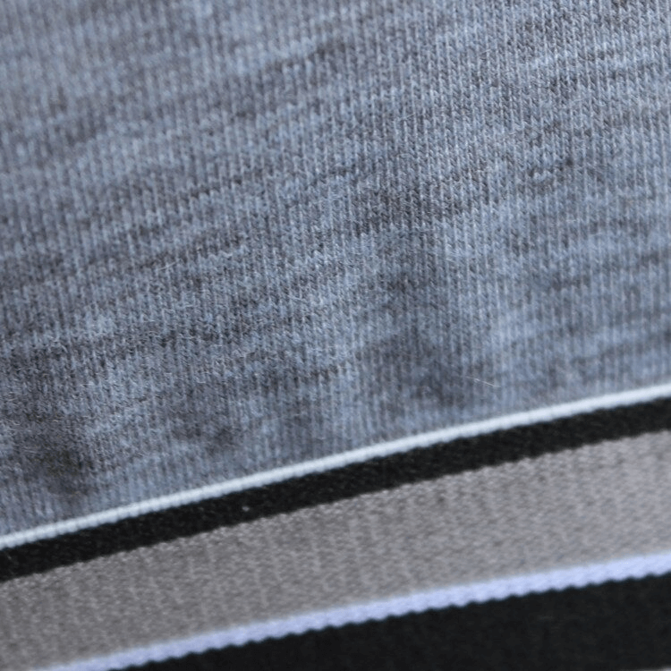 Close-up of gray and black sports fabric showcasing texture and elasticity, ideal for quick-drying activewear.