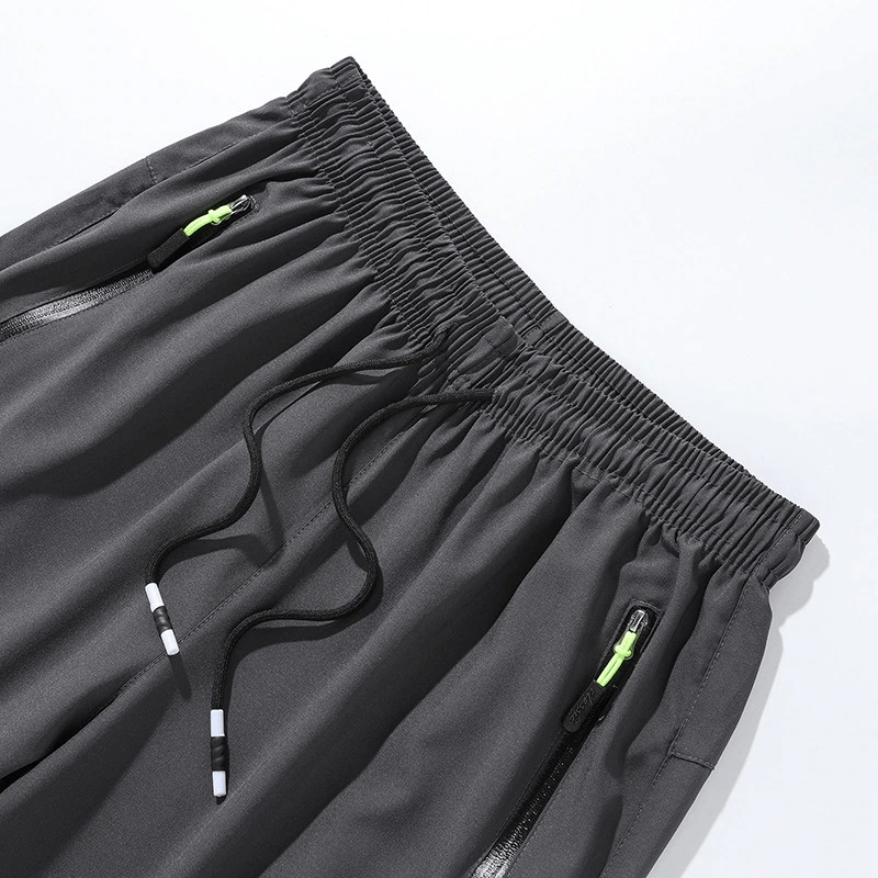 Close-up of gray sports quick-drying men's pants with elastic waist and zippered pockets, perfect for hiking and camping.