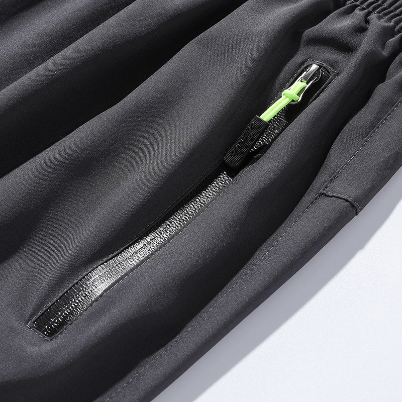 Close-up of zipper pocket on black sports quick-drying men's pants SF0228 with elastic waist and protective polyester fabric.