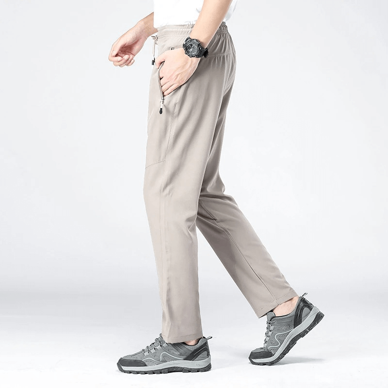 Man wearing beige sports quick-drying pants with pockets, perfect for hiking, showcasing comfort and style.