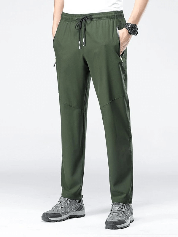 Man wearing green sports quick-drying pants with pockets, ideal for hiking or camping, featuring elastic waist and breathable polyester fabric.