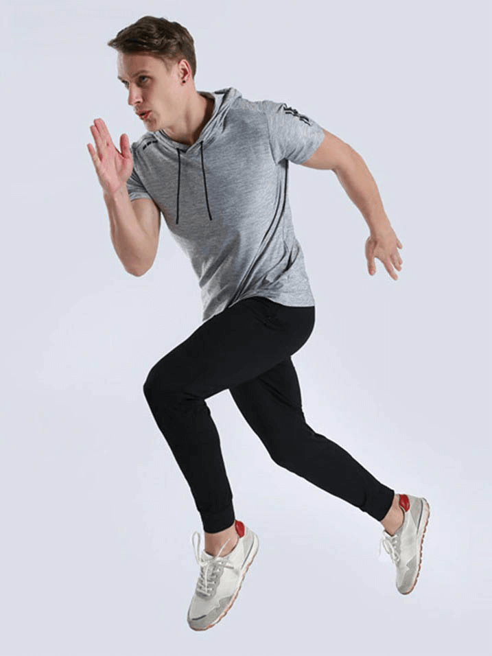 Man wearing gray quick-dry hoodie T-shirt running, showcasing sportswear's breathability and fit for athletic performance.
