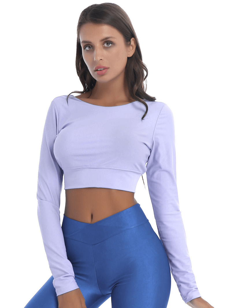 Model wearing lavender sports seamless long sleeves cropped top with back cross strappy, paired with blue leggings.