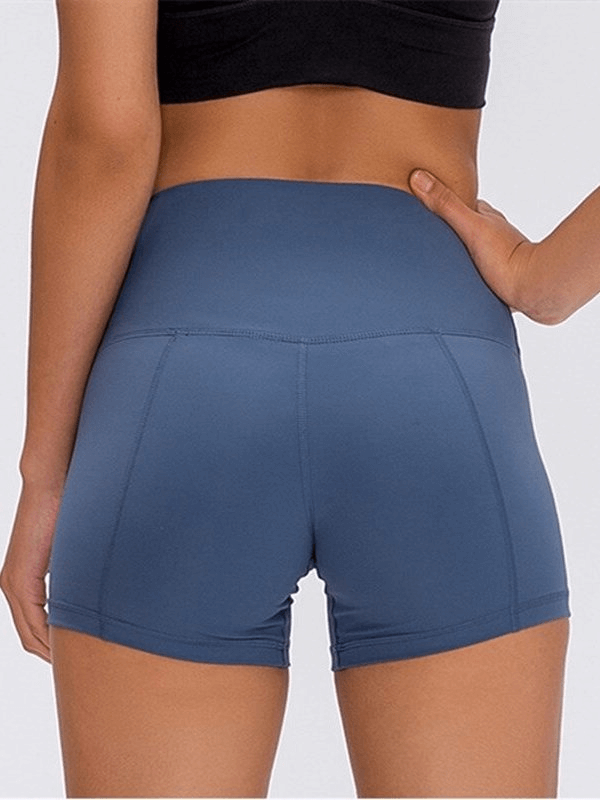 Woman wearing blue elastic sports shorts, showcasing athletic style and comfort for workouts.