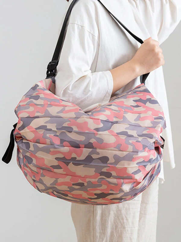 Camo-patterned lightweight waterproof sports shoulder bag for women, perfect for fitness and beach days, held by a model in white.