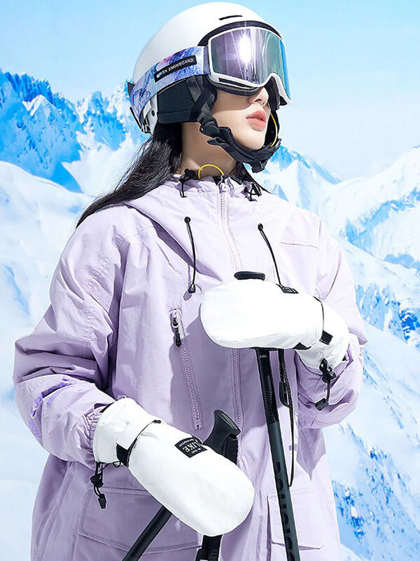 Skiing woman in purple jacket, helmet, and white gloves on snowy mountain