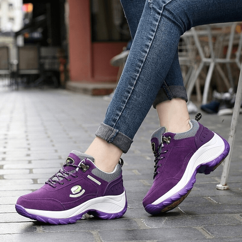 Woman wearing stylish purple suede sneakers with animal print and lace-up design, perfect for sporty chic comfort.