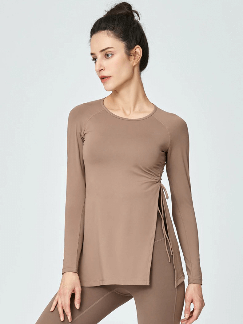 Woman wearing a taupe sports waist drawstring top with slits and full sleeves, showcasing fitness fashion for women, model SF0050.