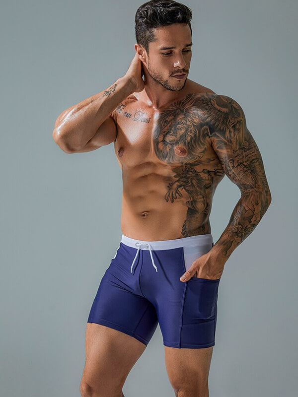 Man wearing blue waterproof beach boxer shorts with drawstring and pockets, showcasing athletic fit and design. Model SF0772.