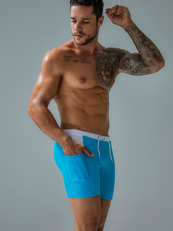 Model wearing blue waterproof beach boxer shorts with drawstring and pockets, perfect for water sports and beach activities.