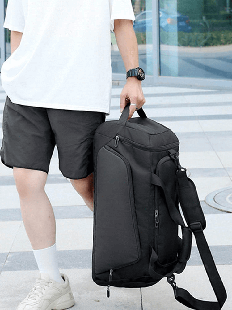 Person holding a black sports waterproof portable bag with a shoe compartment, perfect for fitness, featuring waterproof oxford material.