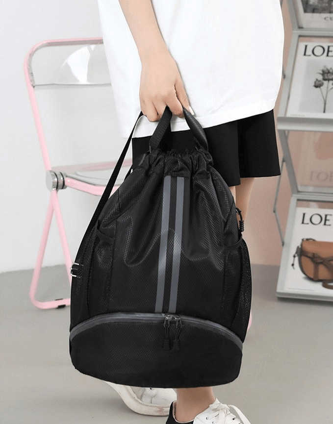 Person holding black sports waterproof shoe bag backpack, ideal for outdoor activities, unisex with 15L capacity, SF0935.