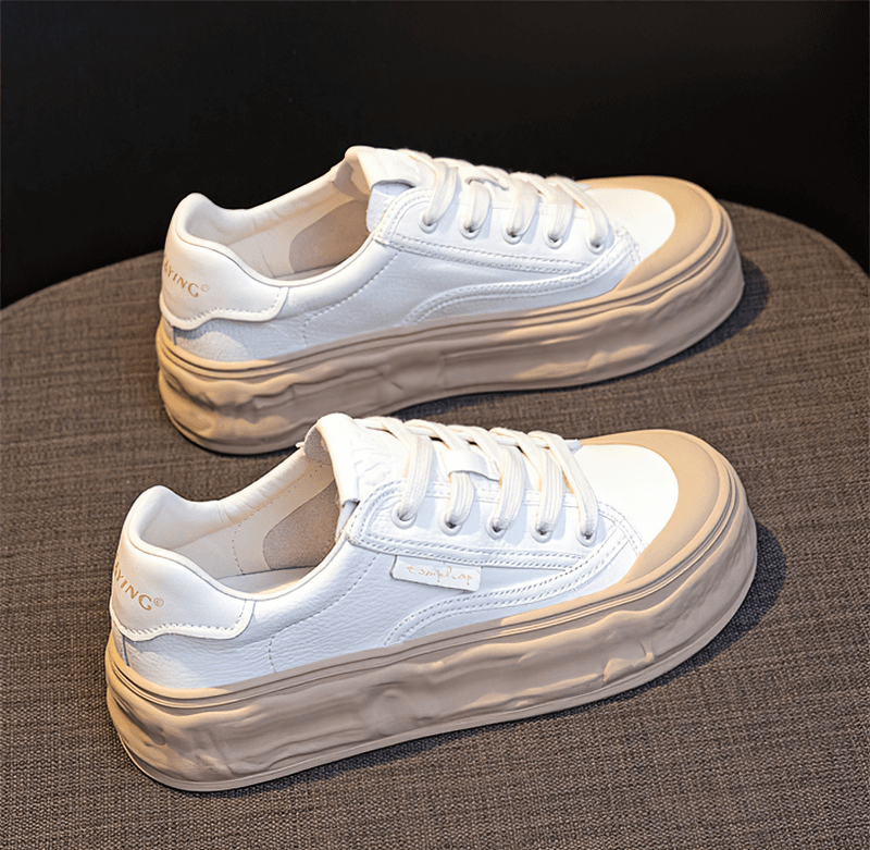 Women's round toe lace-up sneakers with thick sole, in white with cream accents, offering style and comfort for active lifestyles.