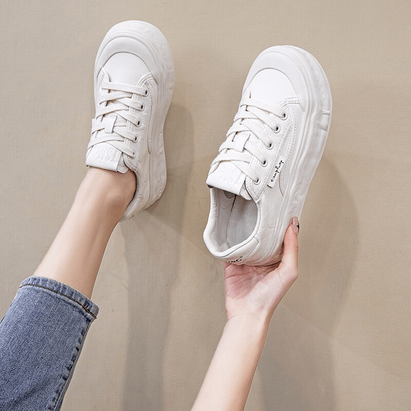 White women's round toe lace-up sneakers with thick sole in a casual setting.