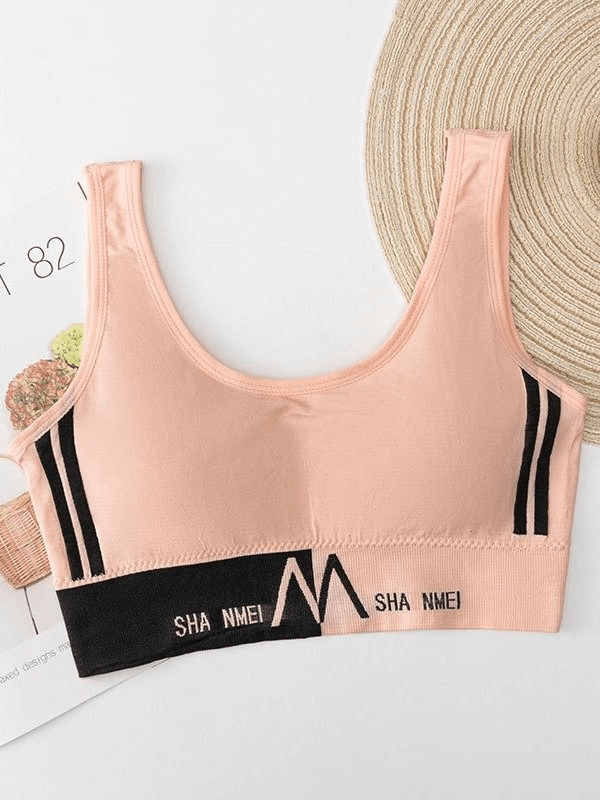 Peach seamless sports bra with black accents, perfect for women's fitness activities; features comfort lining, anti-chafing design.