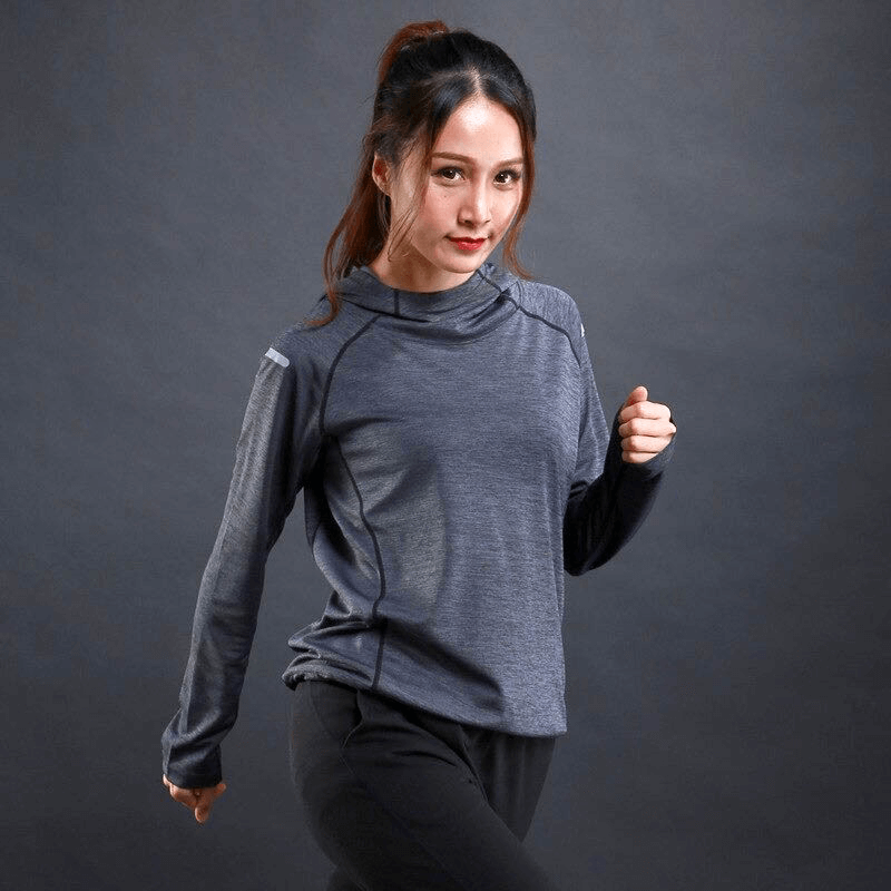 Athletic woman in a breathable thin long sleeves hoodie with reflective design, perfect for gym workouts and running comfort.
