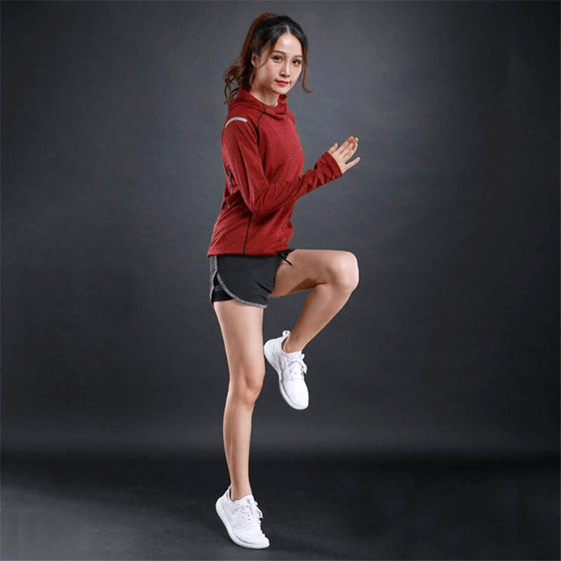 Woman in a red reflective fitness hoodie performing a workout pose, showcasing breathable gym wear for running and exercise enthusiasts.