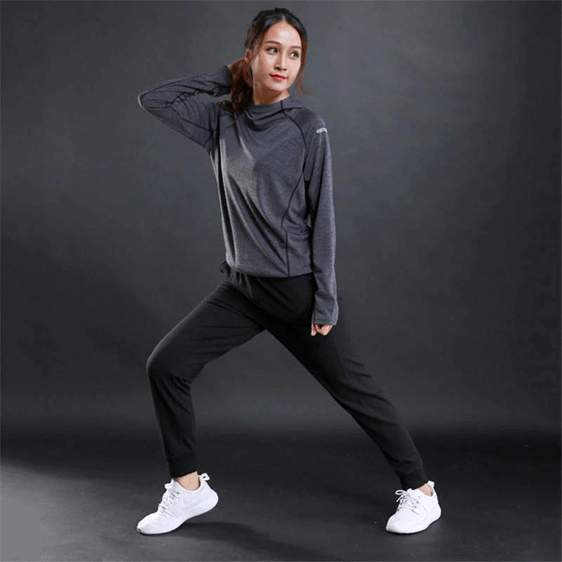 Woman stretching in sports thin long sleeves reflective hoodie, ideal for gym and fitness activities, promoting comfort and safety.