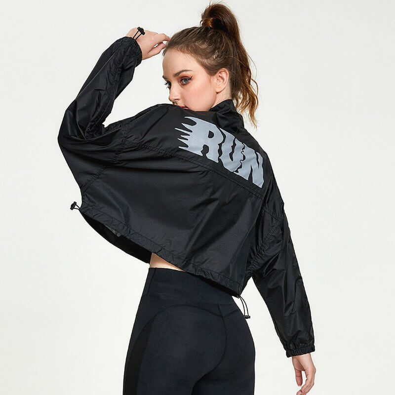 Woman wearing a black sports jacket with "RUN" print, showing back design and loose fit, ideal for running and yoga.