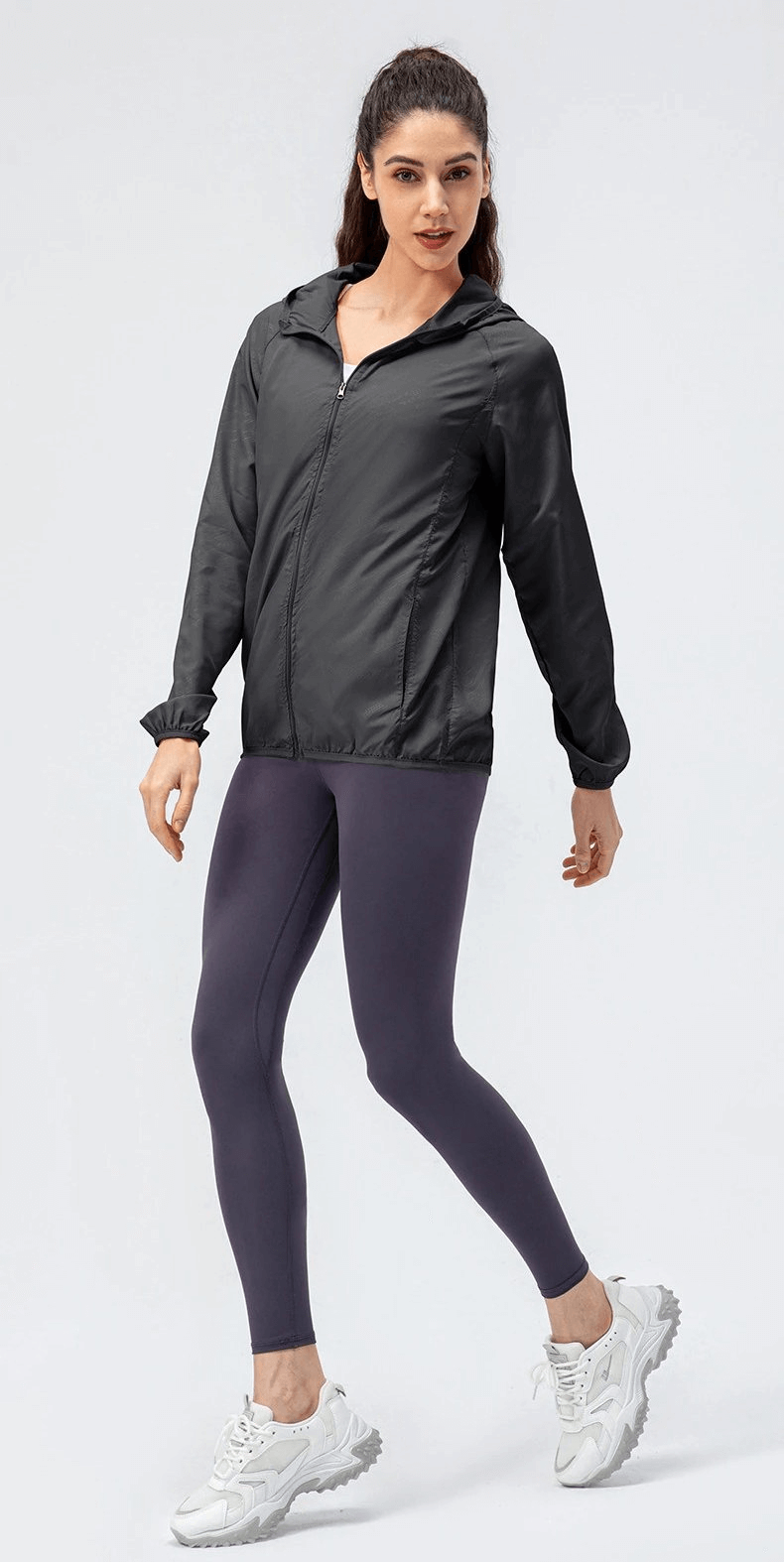 Sports women's waterproof windbreaker with zipper, ideal for running. Features black polyester fabric and hooded design.