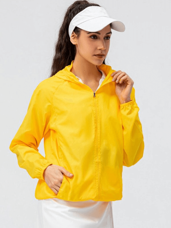 Woman wearing yellow waterproof windbreaker for running with hood and full zipper, ideal for outdoor sports.