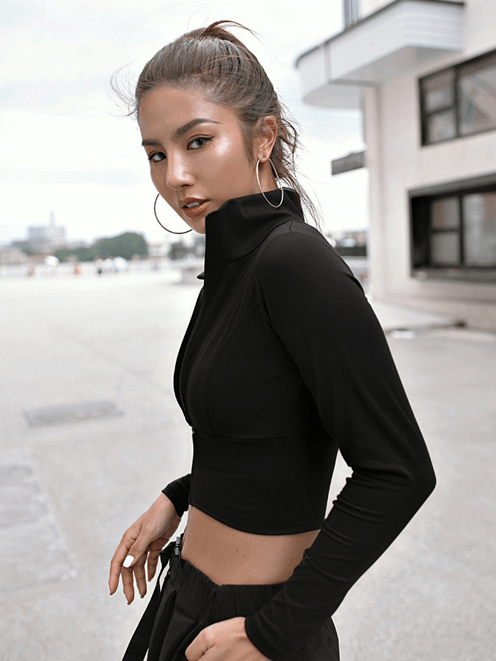 Woman wearing black sports zipper jacket with long sleeves, perfect for running or fitness, featuring Mandarin collar and breathable fabric.