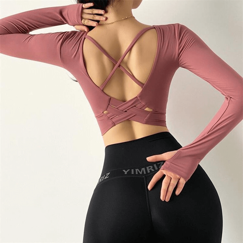 Sporty elastic cropped women's top with open back, long sleeves, quick-dry fabric, and supportive design in a fashionable pink color.