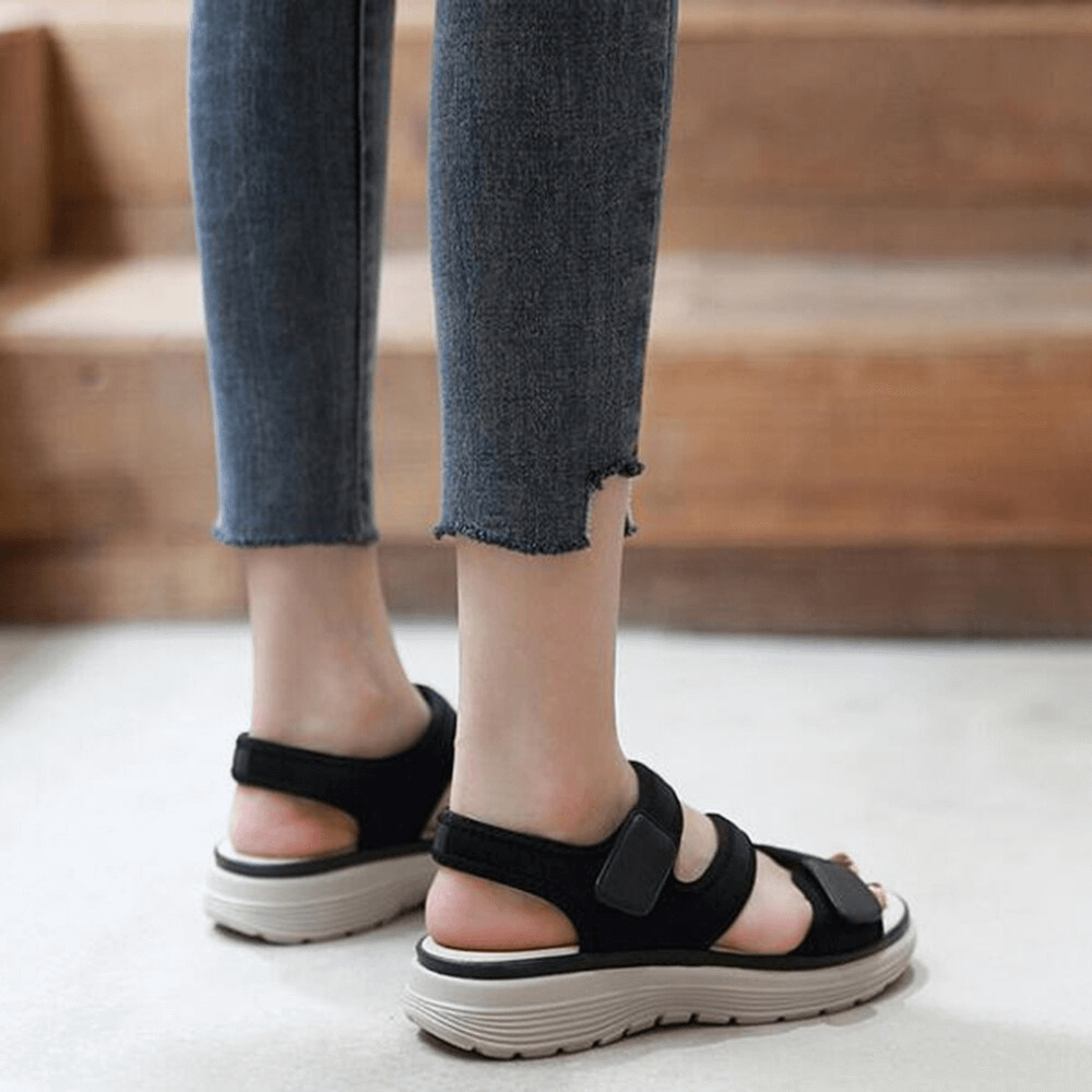 Person wearing sporty flexible women's open-toe flat sandals with fasteners, perfect for casual style and comfort.
