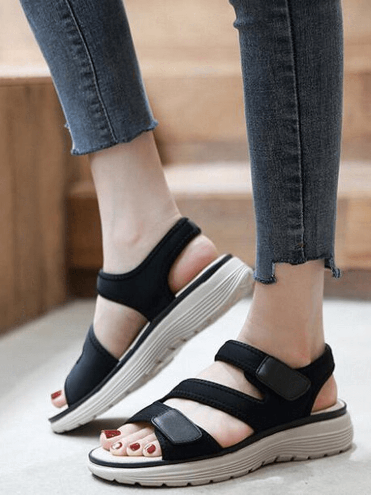 Woman wearing sporty flexible open-toe flat sandals with fasteners, stylish and comfy for casual outings.