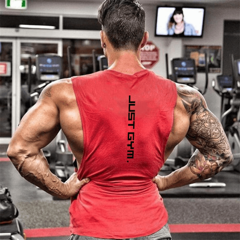 Man at gym wearing a red tank top with dropped armholes, displaying muscular back and arms, perfect for active men's quick-drying workout wear.