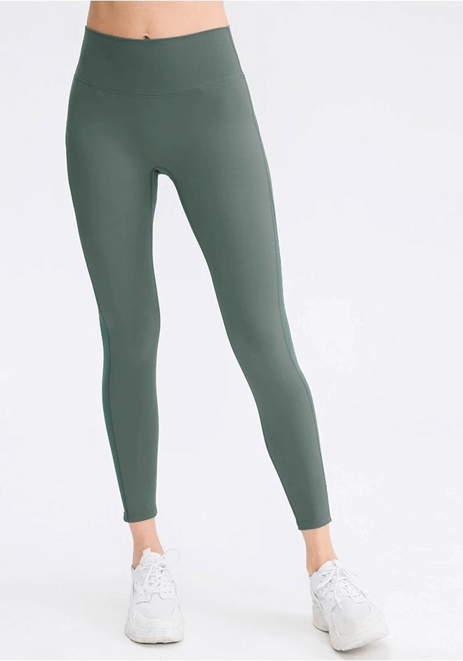 Sporty seamless women's high-waist leggings in green, designed for yoga with flexible, moisture-wicking nylon-spandex blend.
