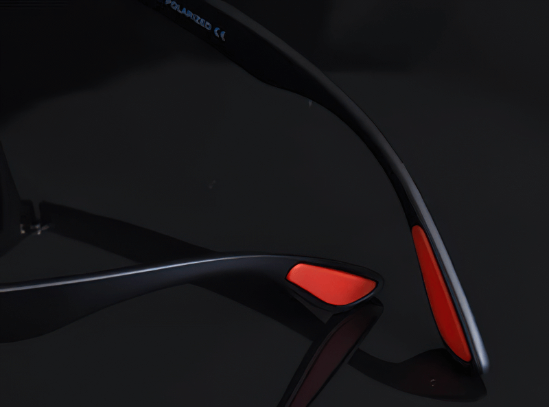 Close-up of black and red ultralight TR90 polarized sunglasses frames on dark background, featuring sleek modern design.