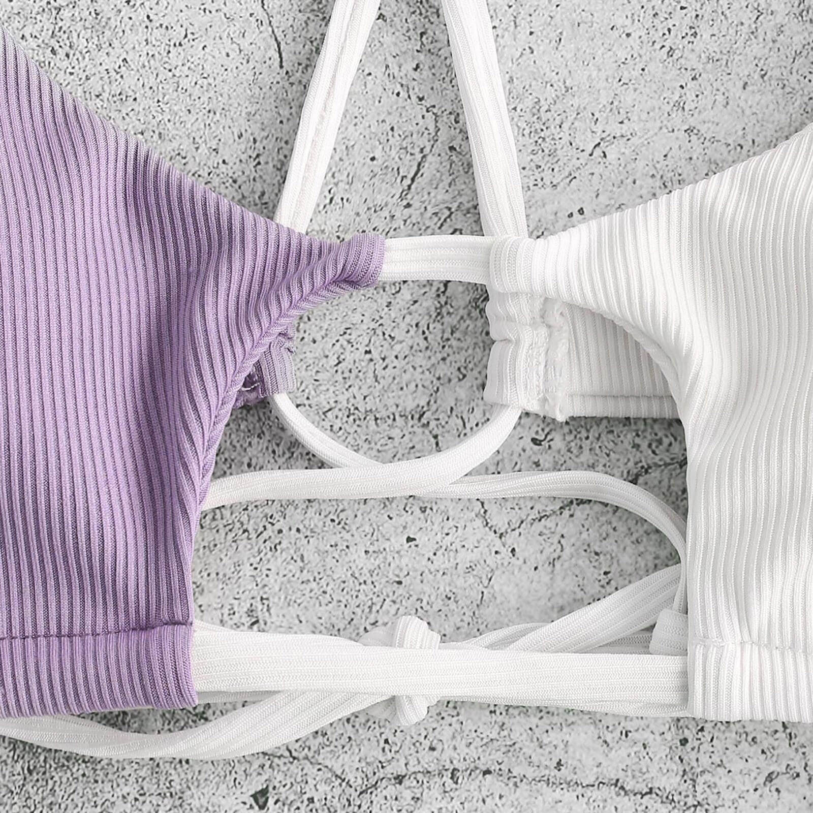 Close-up of stylish string bikinis in purple and white with patchwork design, perfect for a trendy beach look and comfortable wearing.
