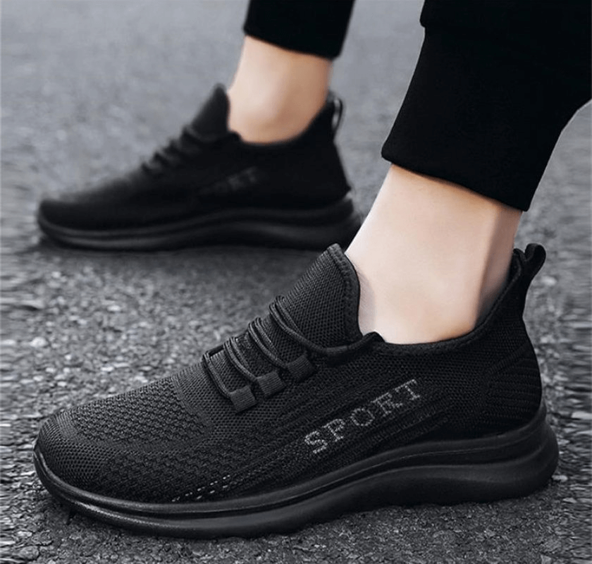 Person wearing stylish breathable elastic lace up sneakers for men, featuring a mesh upper and solid pattern, SF0980 model.