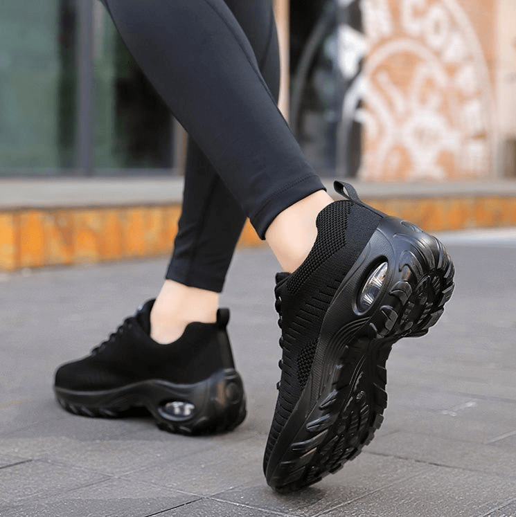 Woman wearing stylish breathable flexible black sneakers SF0775, perfect for outdoor sports, with mesh air upper and non-slip sole
