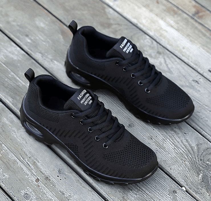 Black stylish breathable women's sneakers SF0775 with mesh air upper, perfect for sport and casual wear, on wooden floor.