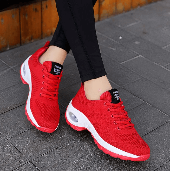Woman wearing red stylish breathable flexible sneakers SF0775 with mesh air upper, EVA insole, and non-slip sole for outdoor activities.
