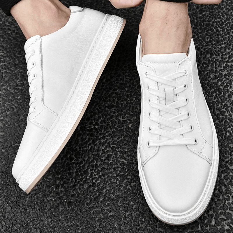 White stylish breathable genuine leather men's shoes with lace-up closure and rubber outsole for comfort and traction on black background.