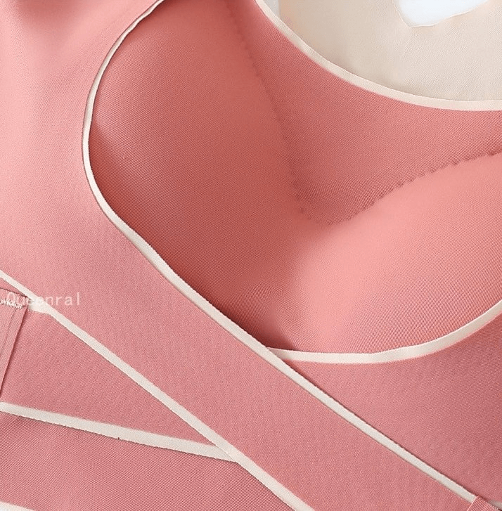 Close-up of pink stylish elastic cross back sports bra with push-up padding and front closure, perfect for active women.