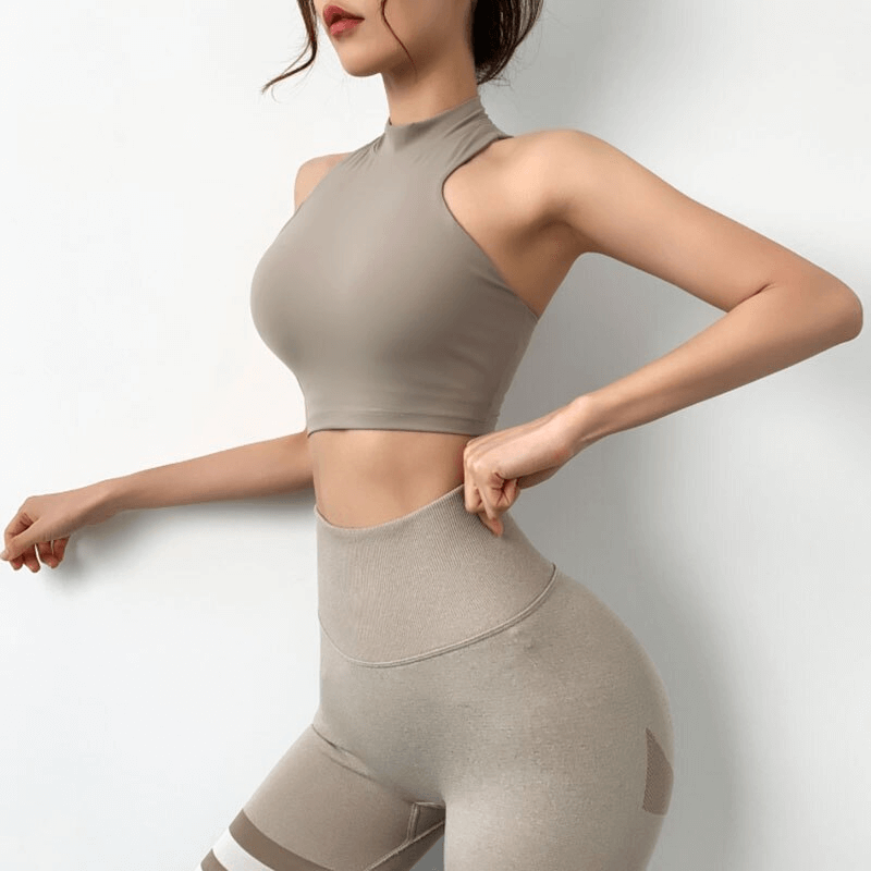 Woman wearing stylish elastic sports bra with open back, perfect for fitness, features breathable quick-dry nylon and adjustable straps.