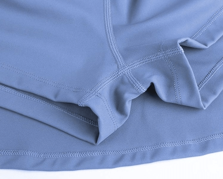 Blue elastic women's tennis short-skirt with pocket detail, highlighting moisture-wicking polyester fabric for comfort on the court.