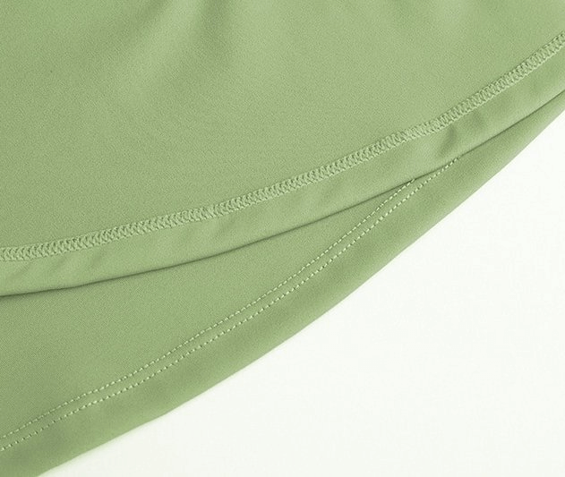 Close-up of stylish elastic women's tennis shorts-skirt in green fabric showcasing quality stitching and material texture.