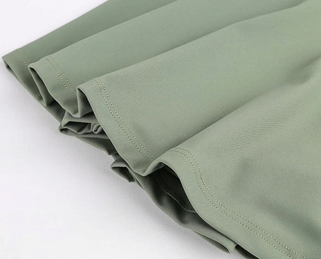 Close-up of stylish women's tennis shorts-skirt in sage green, featuring lightweight fabric and elastic waistband for comfort.