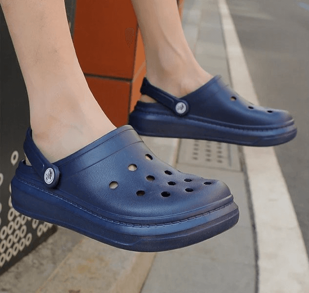 Person wearing navy blue lightweight unisex crocs with platform soles, ideal for casual comfort and durability.