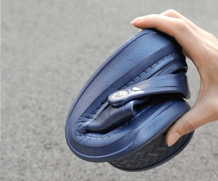 Flexible blue unisex crocs being bent to showcase their lightweight design and durable EVA material.