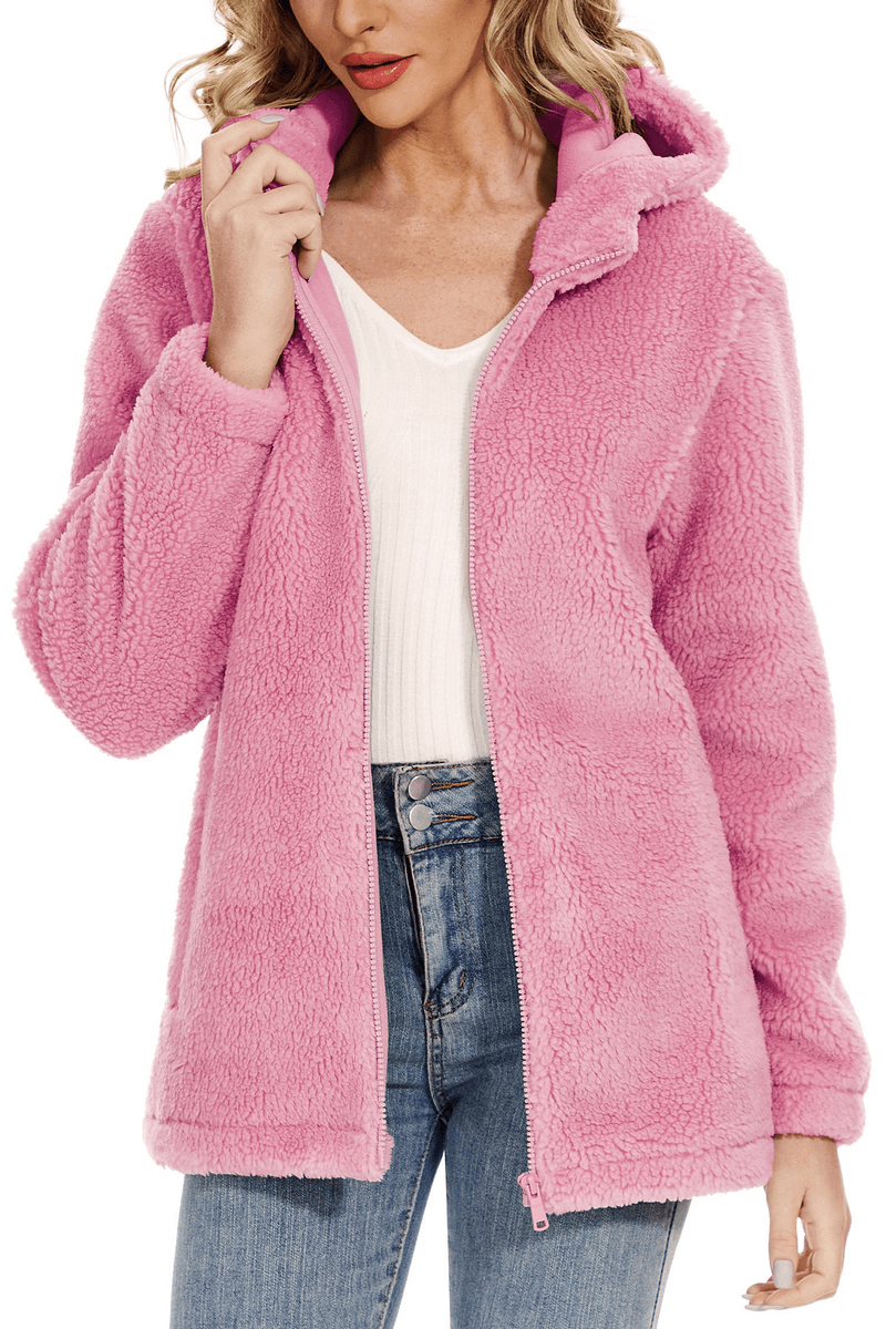 Woman wearing stylish fluffy pink jacket with hood and zipper, ideal for staying cozy and fashionable in colder temperatures.