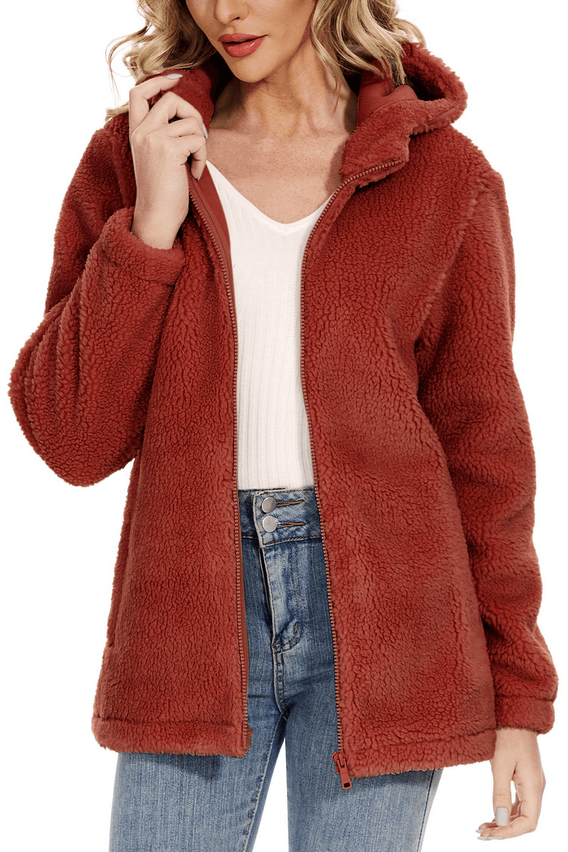 Woman wearing stylish fluffy jacket with hood, perfect for cozy winter warmth and style, featuring a convenient zipper closure and pockets.